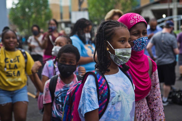 Students wear face masks outside of their school in Philly