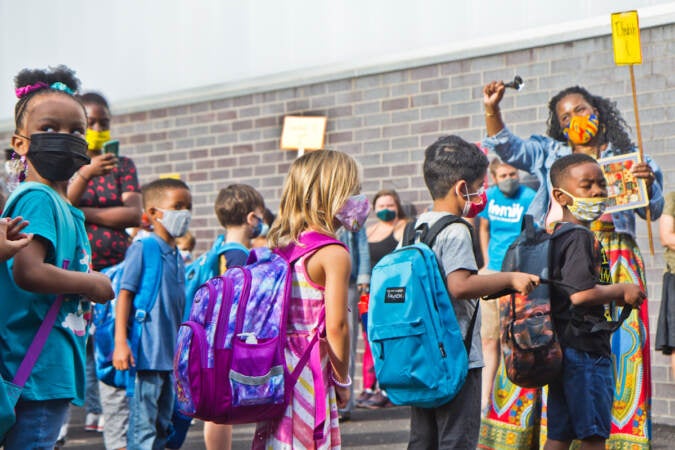 Students wear face masks outside of their school in Philly