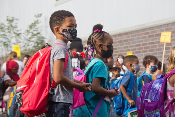 Students wear face masks outside of their school in Philly
