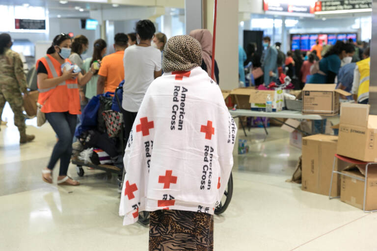 An evacuee wears an American Red Cross blanket inside Philadelphia International Airport