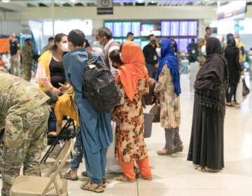 Evacuees stand inside Philadelphia International Airport