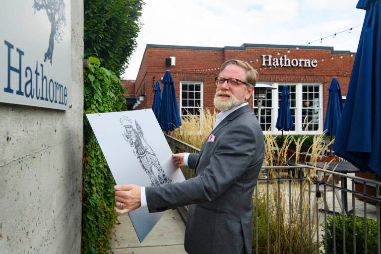 Hathorne restaurant owner John Stephenson holds a sign for a pop-up restaurant which will cover the Hathorne sign when that restaurant is open, Wednesday, Aug. 18, 2021, in Nashville, Tenn. Stephenson hosts temporary restaurants, known as pop-ups which he lets use his space, in an effort to help them weather the pandemic. Most recently, Hathorne hosts the pop-up St. Vito Focacciaria pizza company, which sign he holds, every Sunday night. (AP Photo/John Amis)