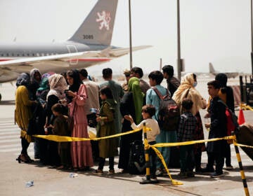 Civilians prepare to board a plane at Hamid Karzai International Airport