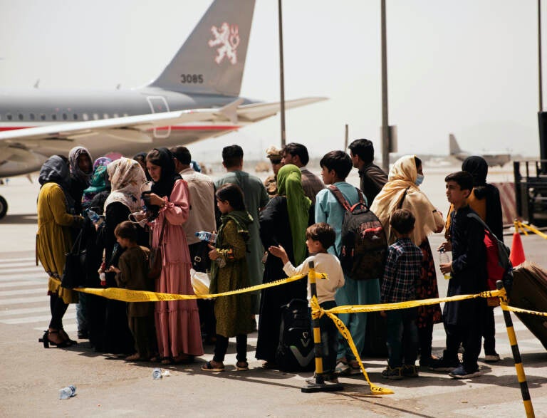 Civilians prepare to board a plane at Hamid Karzai International Airport