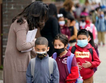 Students wearing face masks line up to enter Christa McAuliffe School