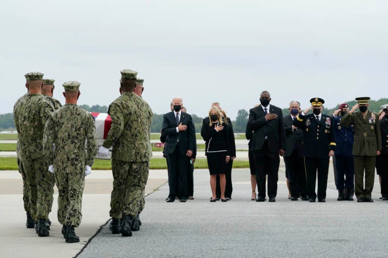 President Joe Biden watches as a Navy carry team moves a transfer case containing the remains of Navy Corpsman Maxton W. Soviak