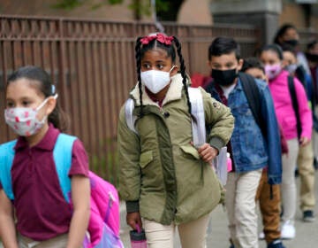 Students line up to enter Christa McAuliffe School while wearing masks
