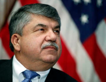 A closeup of Richard Trumka, with an American flag behind him