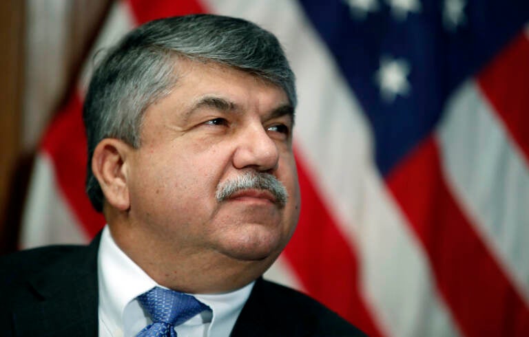 A closeup of Richard Trumka, with an American flag behind him