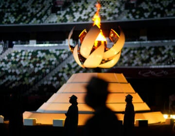 Volunteers stand as International Olympic Committee's President Thomas Bach gives a speech during the closing ceremony in the Olympic Stadium