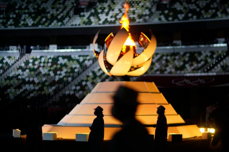 Volunteers stand as International Olympic Committee's President Thomas Bach gives a speech during the closing ceremony in the Olympic Stadium