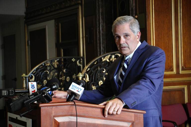 Larry Krasner speaks from a podium during a press conference