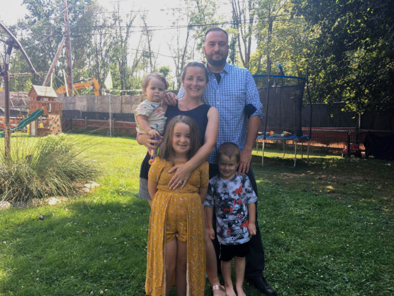 Megan and Bob White with their three kids in their Chester County backyard. Work on the Mariner East 2 pipeline has turned half the property into a construction site, and the project has been plagued by sinkholes and schedule overruns. (Katie Meyer/WHYY)