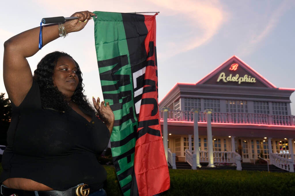 Clarkiya Wilson waves a Black Lives Matter flag outside Adelphia restaurant