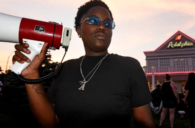 Protester Ajahnae Weal holds a bullhorn outside Adelphia restaruant