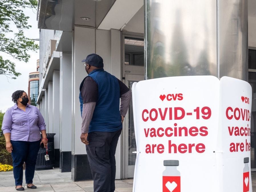 Signs offering COVID-19 vaccinations are seen outside of a CVS pharmacy