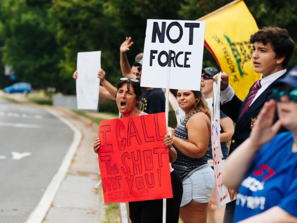 Misty Cunningham yells at a passing motorist while holding a sign that says, "I call the shot."