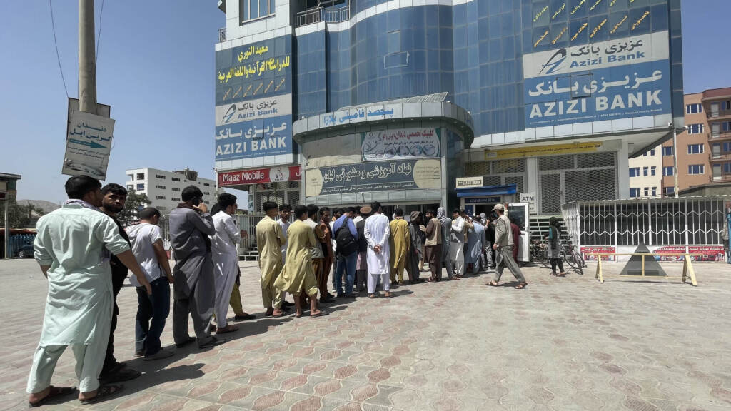 People line up outside Azizi Bank to take out cash