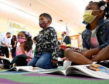Kids listen in a classroom while wearing face masks