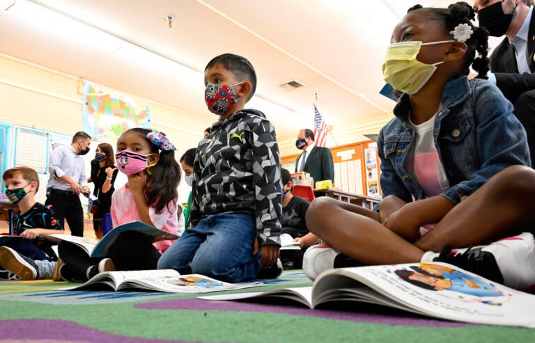 Kids listen in a classroom while wearing face masks