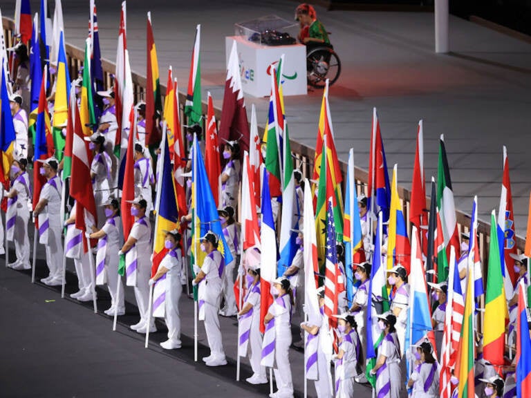 The flags of the participating nations are displayed in the parade of athletes during the opening ceremony of the Tokyo 2020 Paralympic Games