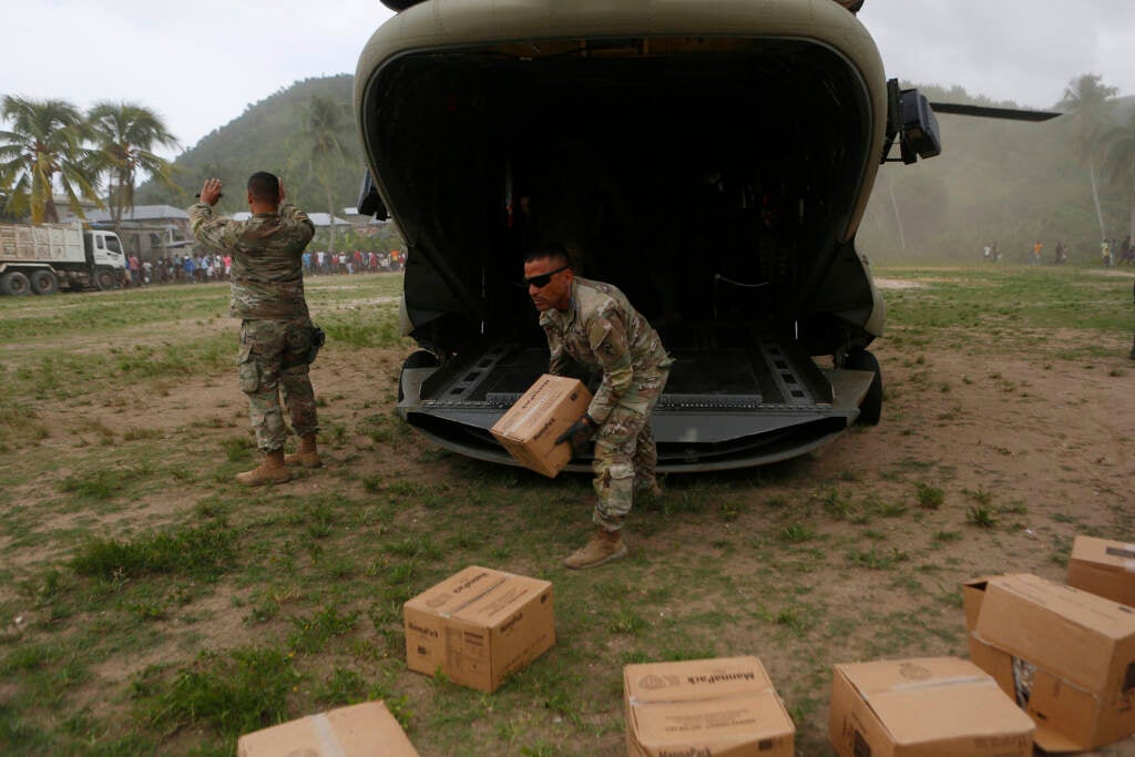 A U.S. Army helicopter unit unloads boxes of humanitarian aid