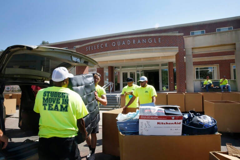 Workers help students move in to Selleck Hall