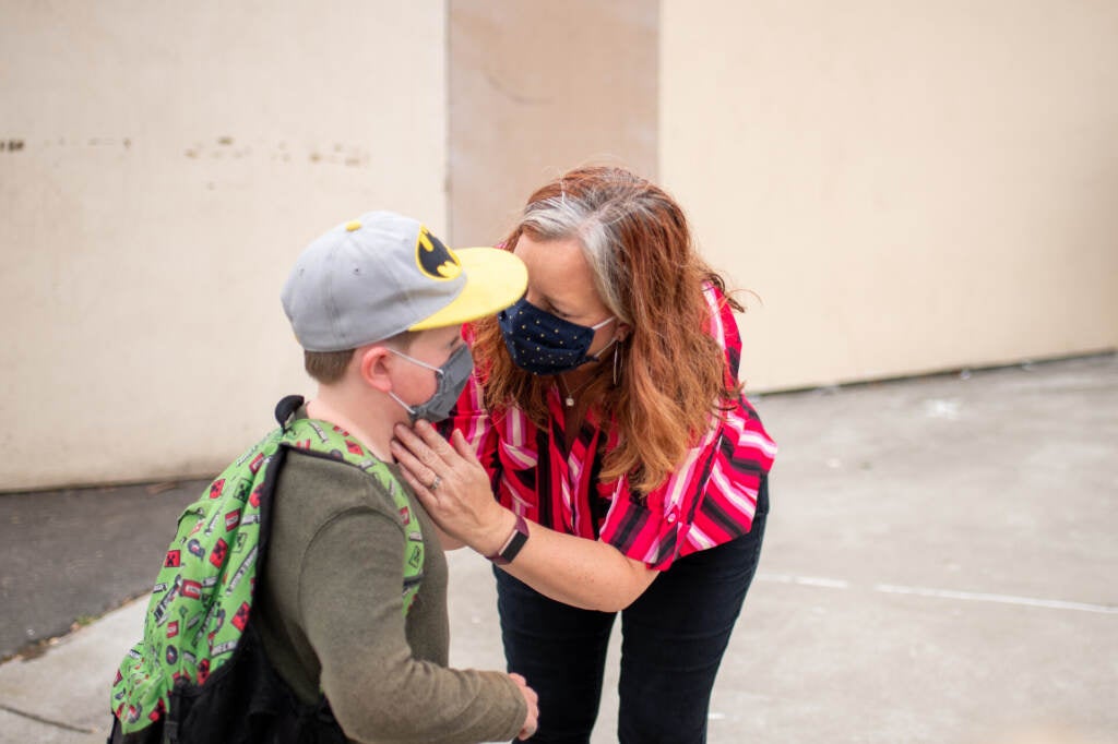 A parent drops off their child at school.