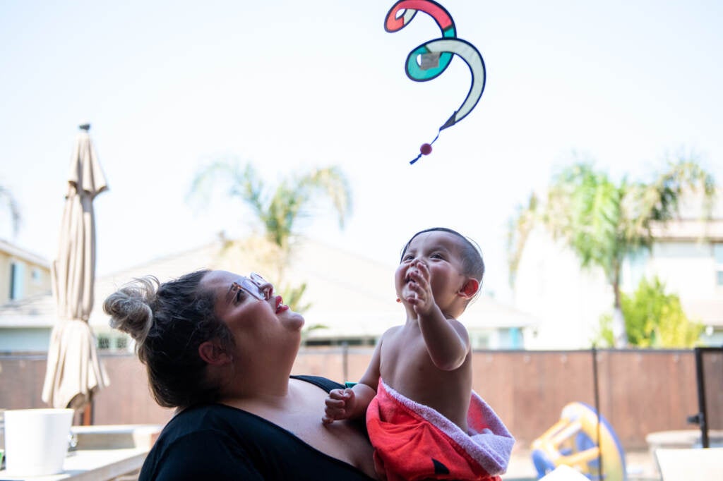 A parent holds their child outside.