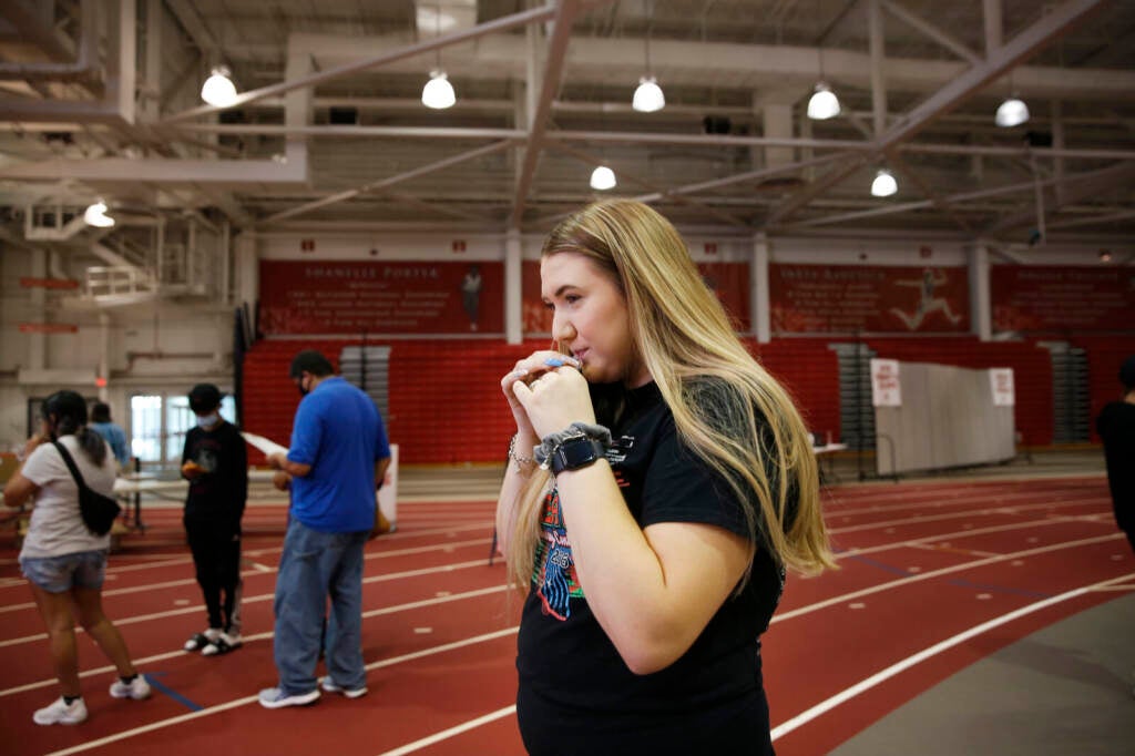 Ariana Huey takes a saliva-based COVID-19 test in a school gym
