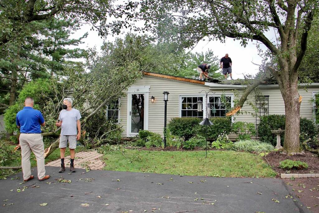 Contractors assess damage to a home in Hidden Springs