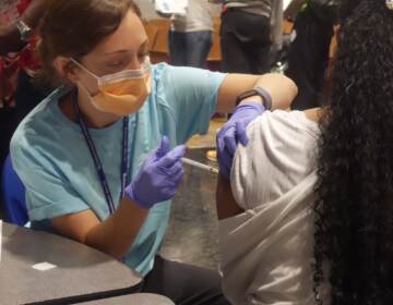A student receives her vaccine at West Philly's Back to School JAM. (Luisa Suarez/WHYY)