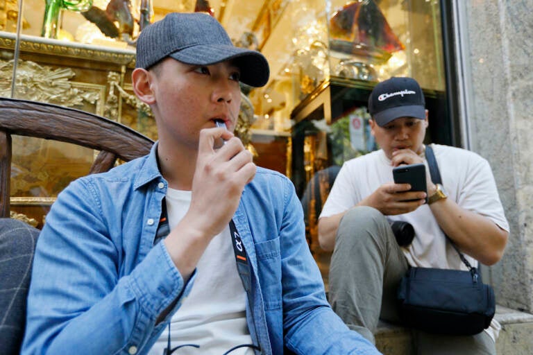 In this Monday, June 17, 2019, file photo, Joshua Ni, 24, and Fritz Ramirez, 23, vape from electronic cigarettes in San Francisco. (AP Photo/Samantha Maldonado, File)