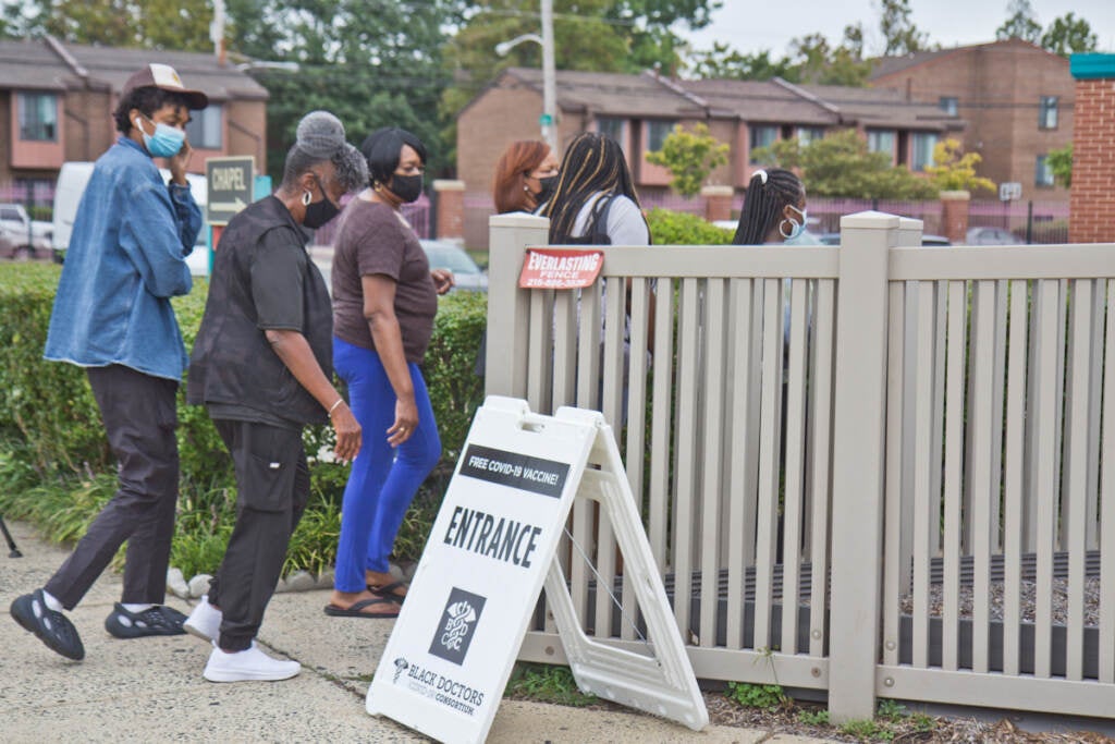 A group of people walk in to receive COVID-19 vaccines at a Philly clinic