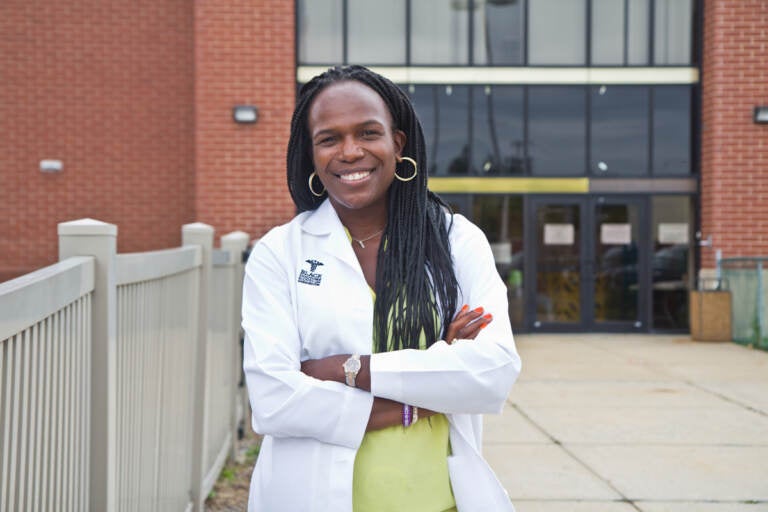 Dr. Ala Stanford stands in front of a health clinic with her arms crossed