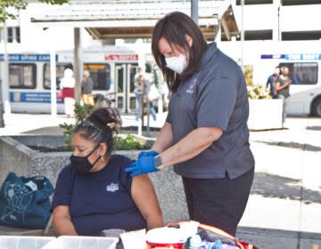 A woman receives the COVID-19 vaccine at Montgomery County Department of Safety’s mobile health vaccination site on September 29, 2021. (Kimberly Paynter/WHYY)