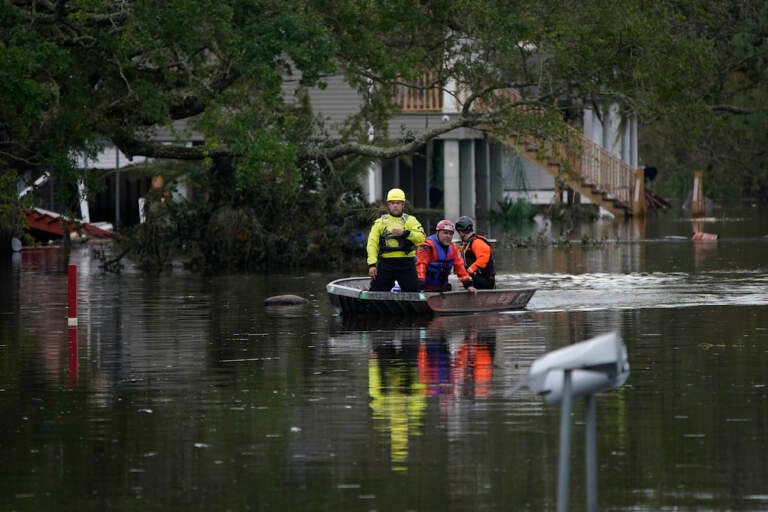 Animal rescue drive a boat down a flooded street