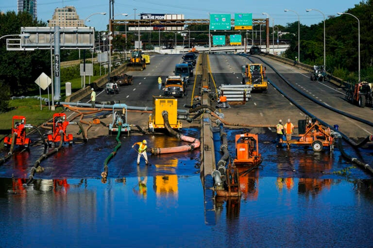 Workers pump water from a flooded section of Interstate 676 in Philadelphia Friday, Sept. 3, 2021