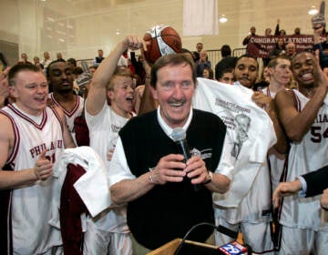 FILE - In this Feb. 1, 2007, file photo, Philadelphia University coach Herb Magee, center, celebrates his 829th career coaching victory, a new NCAA Division II record, with members of the team after they defeated Wilmington College, 65-60 in overtime, in an NCAA college basketball game in Philadelphia. Magee, who has 1,123 victories over a Basketball Hall of Fame career, will retire at the end of this season.  (AP Photo/Tom Mihalek, File)