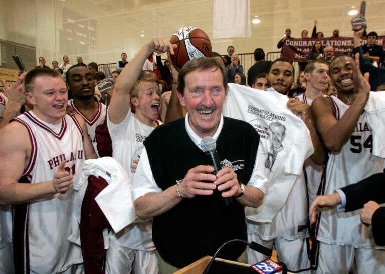 FILE - In this Feb. 1, 2007, file photo, Philadelphia University coach Herb Magee, center, celebrates his 829th career coaching victory, a new NCAA Division II record, with members of the team after they defeated Wilmington College, 65-60 in overtime, in an NCAA college basketball game in Philadelphia. Magee, who has 1,123 victories over a Basketball Hall of Fame career, will retire at the end of this season.  (AP Photo/Tom Mihalek, File)