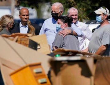 President Joe Biden hugs a person as he tours a neighborhood impacted by Hurricane Ida, Tuesday, Sept. 7, 2021, in Manville, N.J. Sen. Cory Booker, D-N.J., second from left, and New Jersey Gov. Phil Murphy, second from right, look on. (AP Photo/Evan Vucci)