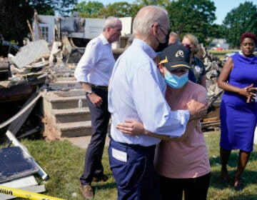 President Joe Biden talks with a person as he tours a neighborhood impacted by Hurricane Ida, Tuesday, Sept. 7, 2021, in Manville, N.J. New Jersey Gov. Phil Murphy, left, and Somerset County Commissioner President Shanel Robinson, right, look on. (AP Photo/Evan Vucci)