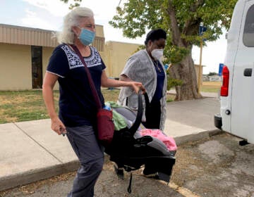 A Hatian refugee is transferred with their newly-born child.