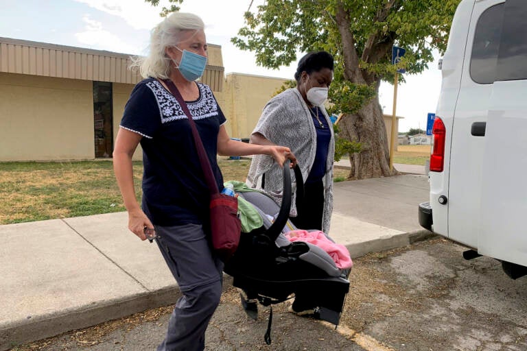 A Hatian refugee is transferred with their newly-born child.