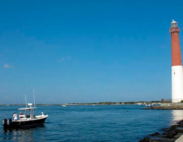 This Sept. 18, 2021 photo shows a boat near the Barnegat Inlet in Barnegat Light, N.J. The inlet is included in a $16 billion flood control plan that would build storm gates that could slam shut across the waterway, a proposal on which the government is seeking public input. (AP Photo/Wayne Parry)