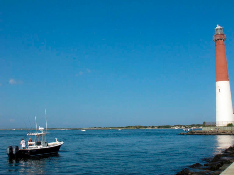 This Sept. 18, 2021 photo shows a boat near the Barnegat Inlet in Barnegat Light, N.J. The inlet is included in a $16 billion flood control plan that would build storm gates that could slam shut across the waterway, a proposal on which the government is seeking public input. (AP Photo/Wayne Parry)