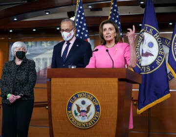 Nancy Pelosi, Chuck Schumer, and Janet Yellen surround a podium
