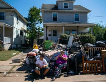 N.J. residents sit alongside belongings damaged by the remnants of Hurricane Ida outside their home