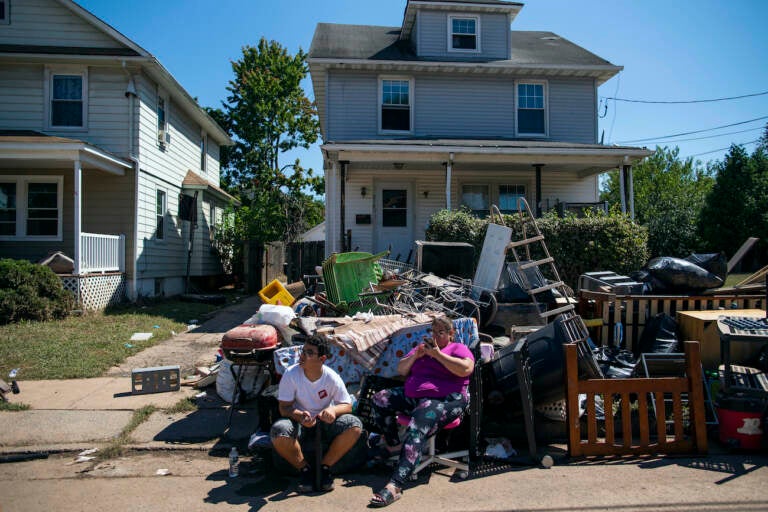 N.J. residents sit alongside belongings damaged by the remnants of Hurricane Ida outside their home