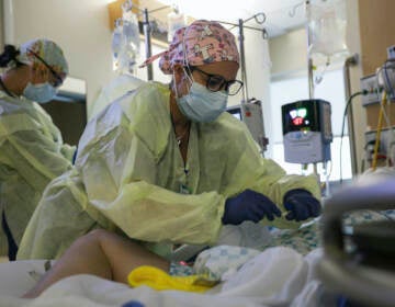 A critical care nurse administers an anti-viral medication to a COVID-positive patien